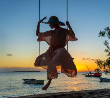 Beautiful girl straw hat pareo swinging swing beach sunset zanzibar island tanzania east africa travel vacation concept 360x320