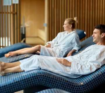 Relaxed couple wearing bathrobes while enjoying health spa focus is man 360x320