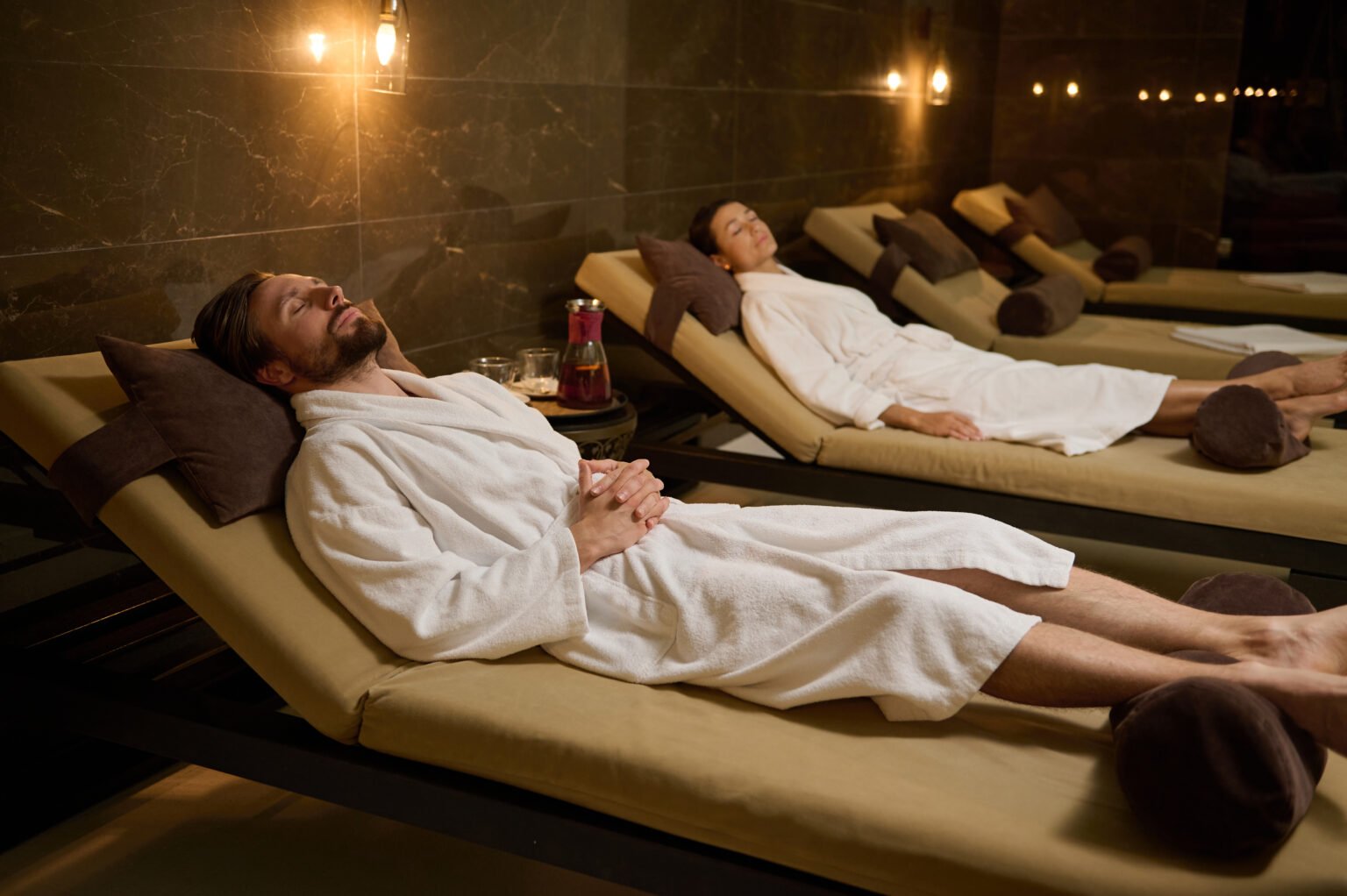 Relaxed newlywed beautiful heterosexual married couple lying down chaise lounge with closed eyes spending time together enjoying serene moments their honeymoon luxury wellness spa center 1536x1022