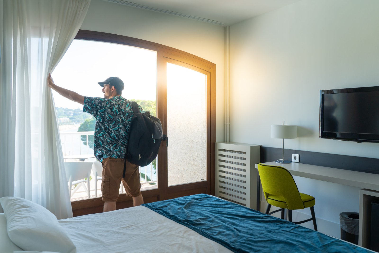 Tourist man hotel bedroom with her luggage standing near window travel vacation concept scaled